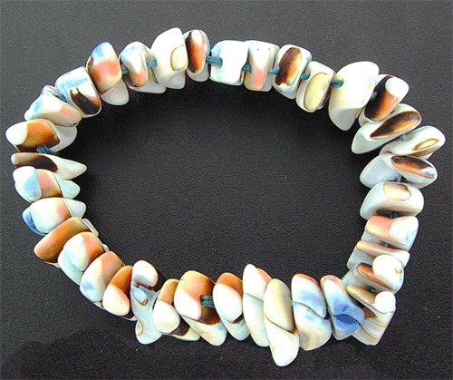 A beautiful stretchable multi-color shell bracelet showcasing natural organic ocean colors like blue, white, orange, and red