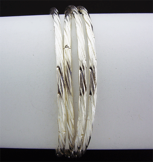 Four-strand silver toned layer bracelet showing detailed craftsmanship and lustrous metallic finish