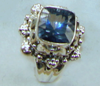 A high-quality 11x11mm Princess Cut Blue Mystic Topaz gemstone set in a premium 925 Sterling Silver Ring