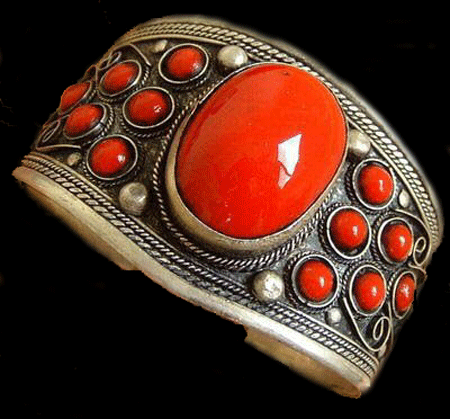 Detailed view of the handcrafted Red Coral Tibet Silver Cuff Bracelet featuring a large oval red coral centerpiece and intricate Tibetan silver detailing