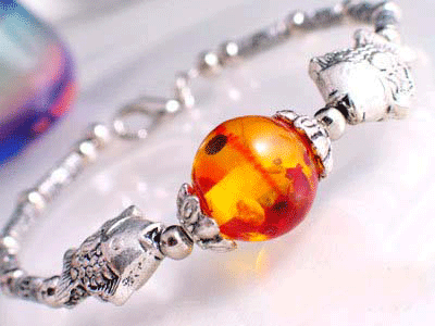 Detailed view of the Tibet Silver Charm Bracelet featuring a central stone and twin fish motifs symbolizing good luck