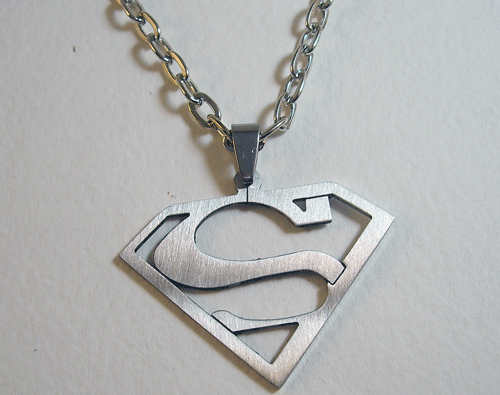 Stainless steel Superman symbol necklace pendant with chain on display